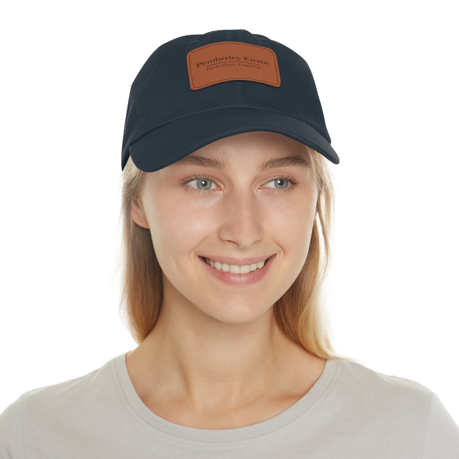 Woman wearing a navy blue cap with a leather patch on a white background