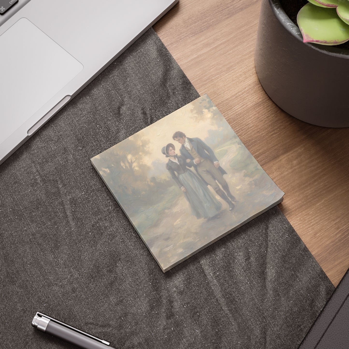 Note pad with a couple illustration on a desk with a pen and plant